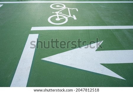 View of bicycles symbol and arrow marking on green bike lane. A Bike Lane is defined as a portion of the roadway that has been designated by striping, signage or exclusive use of bicyclists.