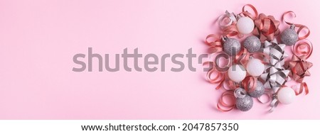 Festive decorations on pastel pink background. Sparkly baubles, ribbons and bows. Christmas banner 16:6