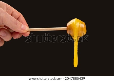 Fresh viscous flower honey falls down from a wooden spoon. vitamin organic food Royalty-Free Stock Photo #2047885439