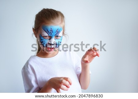 A girl with aqua makeup in the form of a blue water tiger zodiac depicts a tiger on a white background, a concept symbol of the new 2022 year.