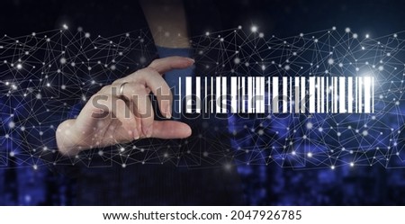 Bar Code Price Tag Merchandise Concept. Hand hold digital hologram Bar Code Price Tag sign on city dark blurred background. Inventory Logistics Concept.