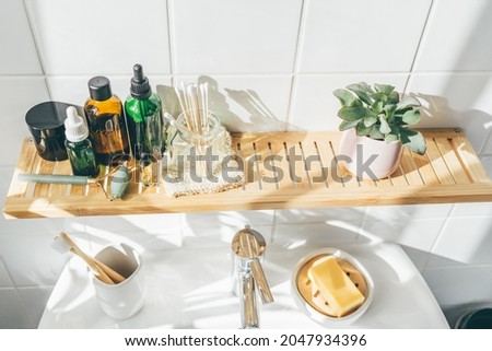 Zero waste bamboo and reusable cosmetic items and toiletries against white wall in bathroom. Organic cosmetis. Wellness and sustainability concept Royalty-Free Stock Photo #2047934396