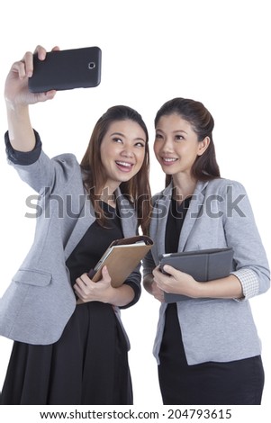 Young businesswomen taking self portrait on white background