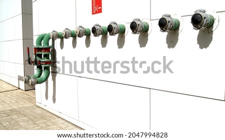 Green fire hydrants on the wall of the building to connect to a fire engine. Close-up.