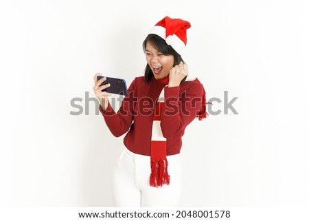 Playing Mobile Game and win of Beautiful Asian Woman Wearing Red Turtleneck and Santa Hat  Isolated On White Background