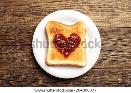 Toast with jam in shape of hearts on wooden background. Top view Royalty-Free Stock Photo #204800377