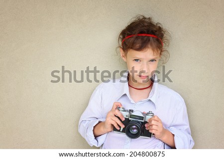 cute kid photographer  holding vintage camera during playing activity. inspiration concept.