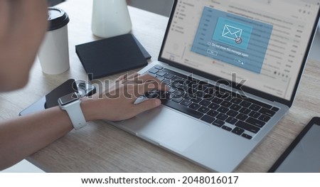 Blocking spam e-mail, warning pop-up for phishing mail, network security concept. Business woman working on laptop computer at home with warning window on screen Royalty-Free Stock Photo #2048016017
