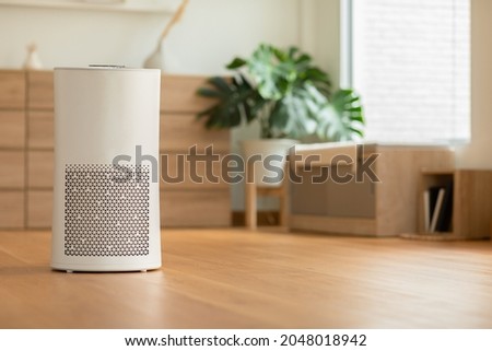Air purifier in cozy white living room for filter and cleaning removing dust PM2.5 HEPA and virus in home,for fresh air and healthy Wellness life,Air Pollution Concept Royalty-Free Stock Photo #2048018942