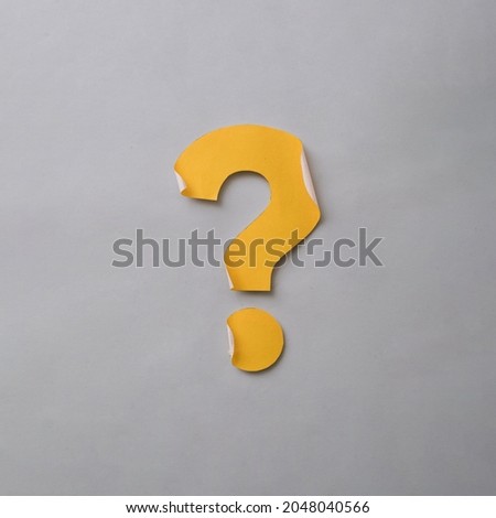 Yellow cut out question mark with curled edges over a grey card background in a conceptual image with copy space Royalty-Free Stock Photo #2048040566