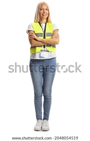 Full length portrait of a young female wearing a reflective vest and posing with crossed arms isolated on white background Royalty-Free Stock Photo #2048054519