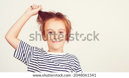 Children style and fashion. Happy boy with stylish hairstyle. Portrait of funny boy. Kid having fun and laughing. Happy childhood and positive emotions. Face expression. Smiling boy posing at studio.