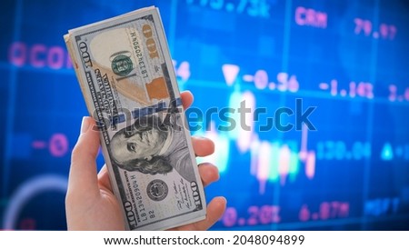 Holding Dollar bills in the stock market. Investors counting money after making it big on the stock market. becoming rich and wealthy. online stock market information.  Royalty-Free Stock Photo #2048094899