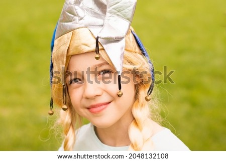 happy blonde girl 9 years old  in clown hat, carnival hat, masquerade  party