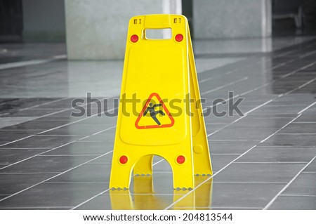 Slippery floor surface warning sign and symbol in building, hall, office, hotel , restaurant, restroom. Concept photo danger. 