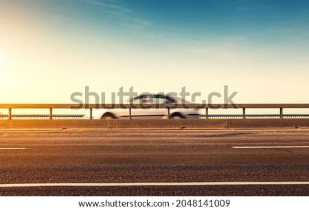 Car in blurred motion on the road, against a sky background. Selective focus