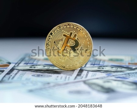 Bitcoin new virtual money and banknotes of 100 dollars. Exchange bitcoin for a dollar. Concept. Closeup