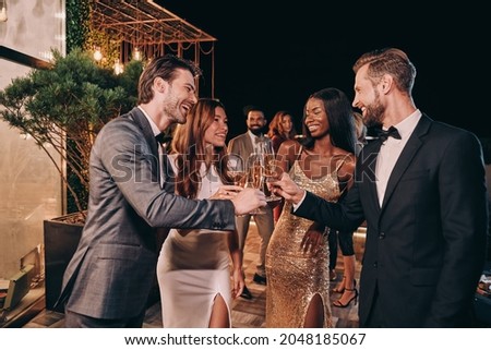Group of people in formalwear communicating and smiling while spending time on luxury party Royalty-Free Stock Photo #2048185067