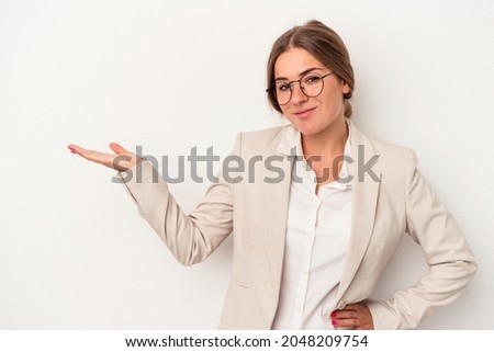 Young Russian business woman isolated on white background showing a copy space on a palm and holding another hand on waist.