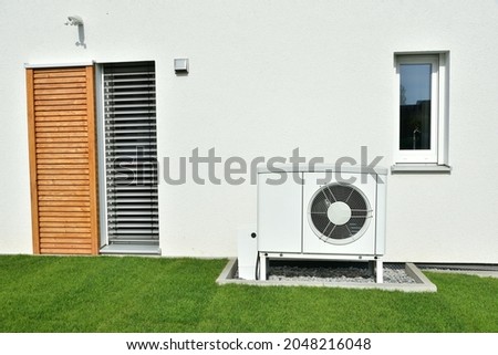 Air-Air Heat Pump for Heating and hot Water in Front of an new built Residential Building Royalty-Free Stock Photo #2048216048