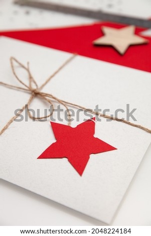 A Christmas gift wrapped in paper and decorated with a red star. DIY real idea. Holidays concept.