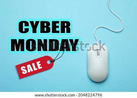 Text Cyber Monday Sale and wired computer mouse on light blue background, top view