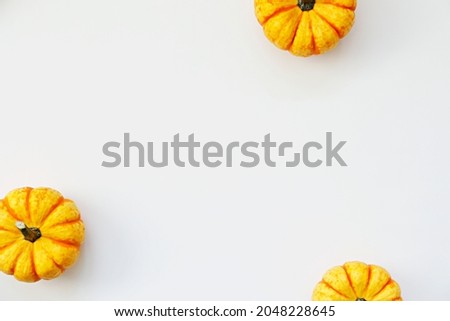 Close up shot of three hooligan pumpkins isolated on bright background as a symbol of autumnal holidays with a lot of copy space for text. Top view, flat lay.