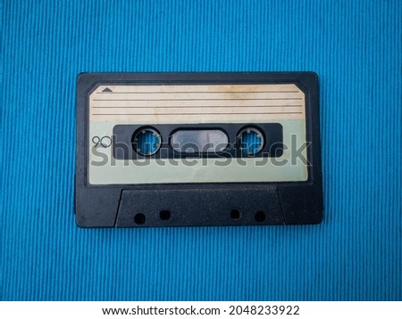 Single Retro Audio Tape Cassettes on a Blue Fabrics Background