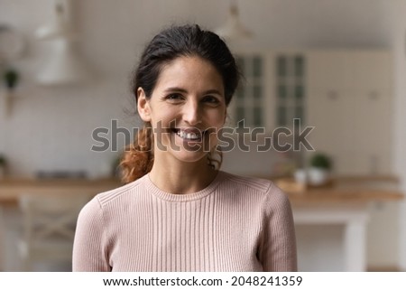 Headshot portrait of smiling young Caucasian woman renter or tenant pose in modern cozy home. Profile picture of happy millennial female feel optimistic positive. Real estate, realty, rent concept.