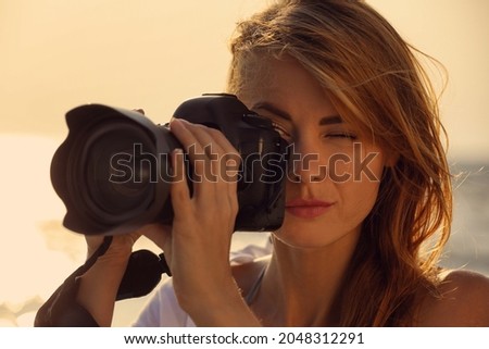Photographer taking photo with professional camera outdoors, closeup