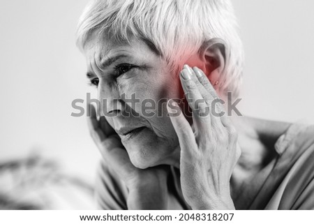 Senior Woman Suffering From Tinnitus  Royalty-Free Stock Photo #2048318207