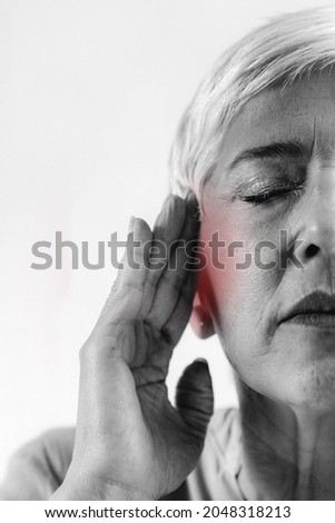 Tinnitus. Senior woman suffering from tinnitus. Royalty-Free Stock Photo #2048318213