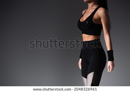 cropped view of sportive woman in sportwear on black Royalty-Free Stock Photo #2048326961