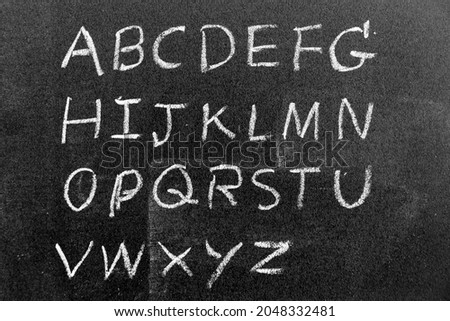 White color chalk hand drawing in english capital letter shape on black board background