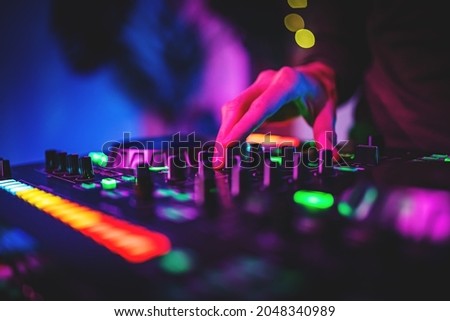 DJ Hands creating and regulating music on dj console mixer in concert nightclub Royalty-Free Stock Photo #2048340989