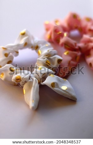Two polka dot scrunchies on pastel background. Selective focus.