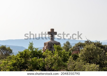 Christian cross with mountains on the background, Pic Saint-Loup mountain in Languedoc-Roussillon, southern France, Europe