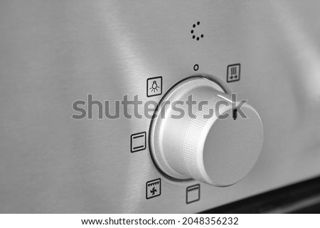 Oven cooking temperature control knob. Kitchen equipment panel detail. Stove