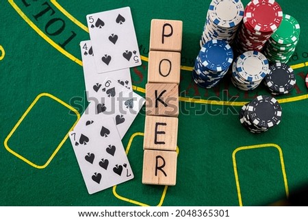 on a green poker table are cards, chips and the inscription poker on wooden cubes. Poker concept
