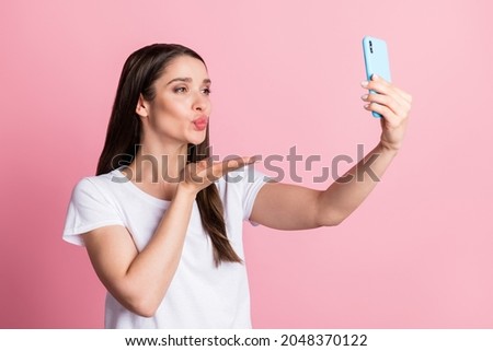 Photo portrait young woman taking selfie sending air kiss isolated pastel pink color background