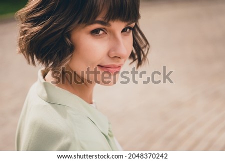 Photo of sweet adorable young lady dressed green shirt walking smiling outdoors urban park
