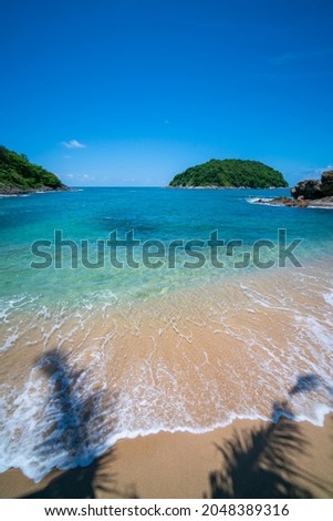 Vertical image view of Summer beach sea with island in summer sun blue sky background.