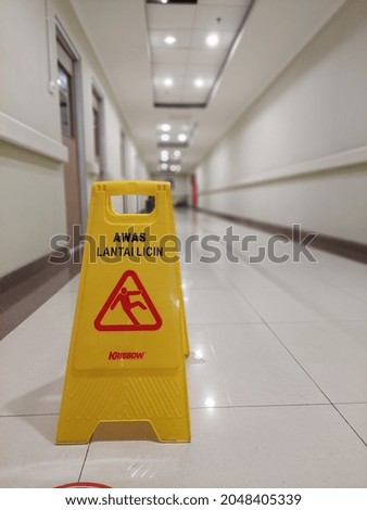 A yellow wet floor sign in the hospital hallway