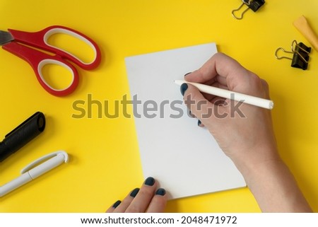 Creative workspace background mockup with hand holding a pen. Stationery set. Back to school. Top view desktop with blank space. Flat lay style
