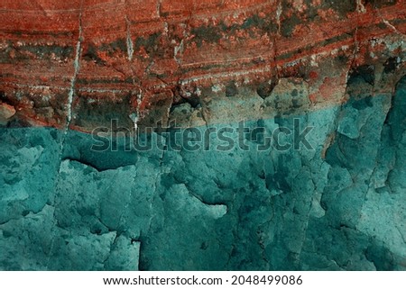 Detail rock abstract surface for background. Rock texture in dark tones of blue, red and gray colors. Vintage color. Rough surface top view, lines and craks. Intense and saturated colors. Vintage hue.