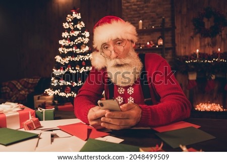 Photo portrait amazed santa wearing glasses using smartphone browsing internet