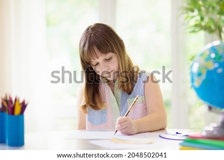Child drawing rainbow. Paint on hands. Remote learning and online school art homework from home. Arts and crafts for kids. Little girl drawing bright picture. Creative kid playing and studying.