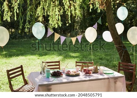 Background image of Summer picnic table outdoors decorated with balloons for Birthday party, copy space