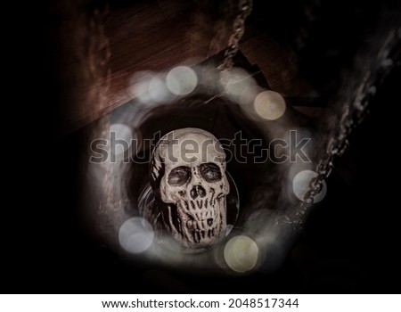 Dummy human skull surrounded by candles on chains