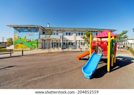 Preschool building exterior with playground on a sunny day Royalty-Free Stock Photo #204852559